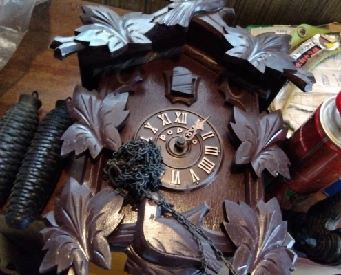 昭和時代の木彫り鳩時計。葉の装飾と鳥の彫刻が美しく施された本体が正面から撮影されている。