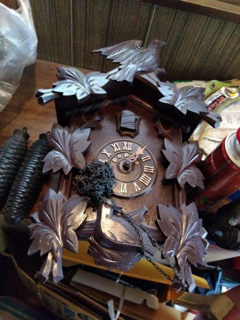 昭和時代の木彫り鳩時計。葉の装飾と鳥の彫刻が美しく施された本体が正面から撮影されている。