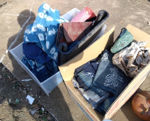 藍染絞りや刺し子風古布を一点一点広げて確認する様子|東京都中野区丸山での遺品整理・古布の出張買取