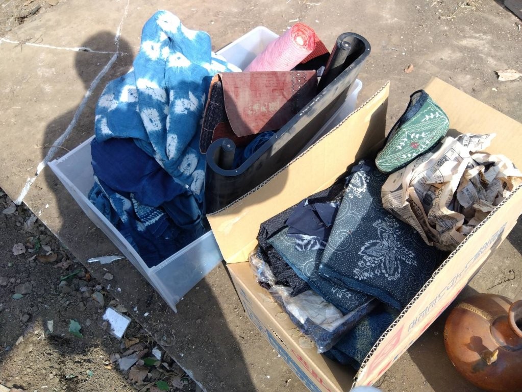 藍染絞りや刺し子風古布を一点一点広げて確認する様子｜東京都中野区丸山での遺品整理・古布の出張買取