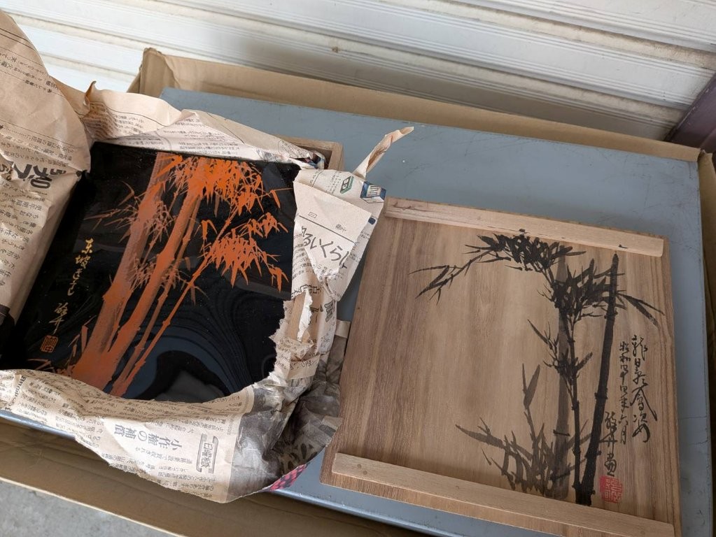 黒漆に朱色で竹文様が描かれた漆器と、墨絵で竹が描かれた共箱を並べたイメージ画像｜漆器の文化的背景と市場価値を表現