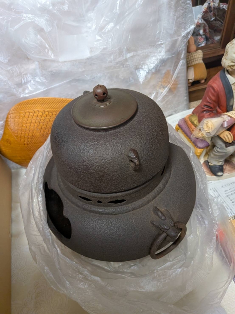 葛飾区水元にて遺品整理で見つかった龍頭耳付きの茶釜を正面から撮影した様子