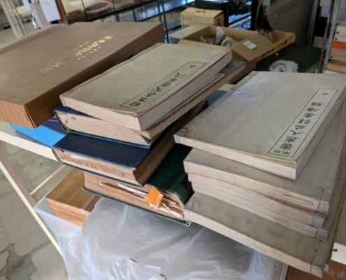 渋谷区笹塚のご実家から出てきた和綴じ本・軍事図録・美術資料の古書一式を査定前に並べた様子｜表紙のヤケや経年劣化が見える古書コレクション