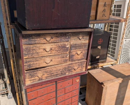 大正から昭和初期にかけて使われた薬箪笥を再現したイメージイラスト。多数の小引き出しと経年の風合いが強く残る古民具の特徴を表現した画像