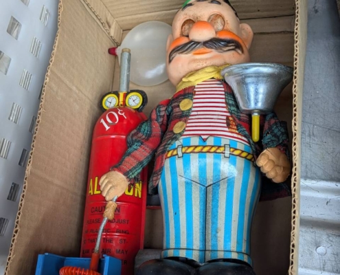 段ボール内に収まった昭和ブリキ玩具の消防士人形と消火器ギミックの全体（箱なし）